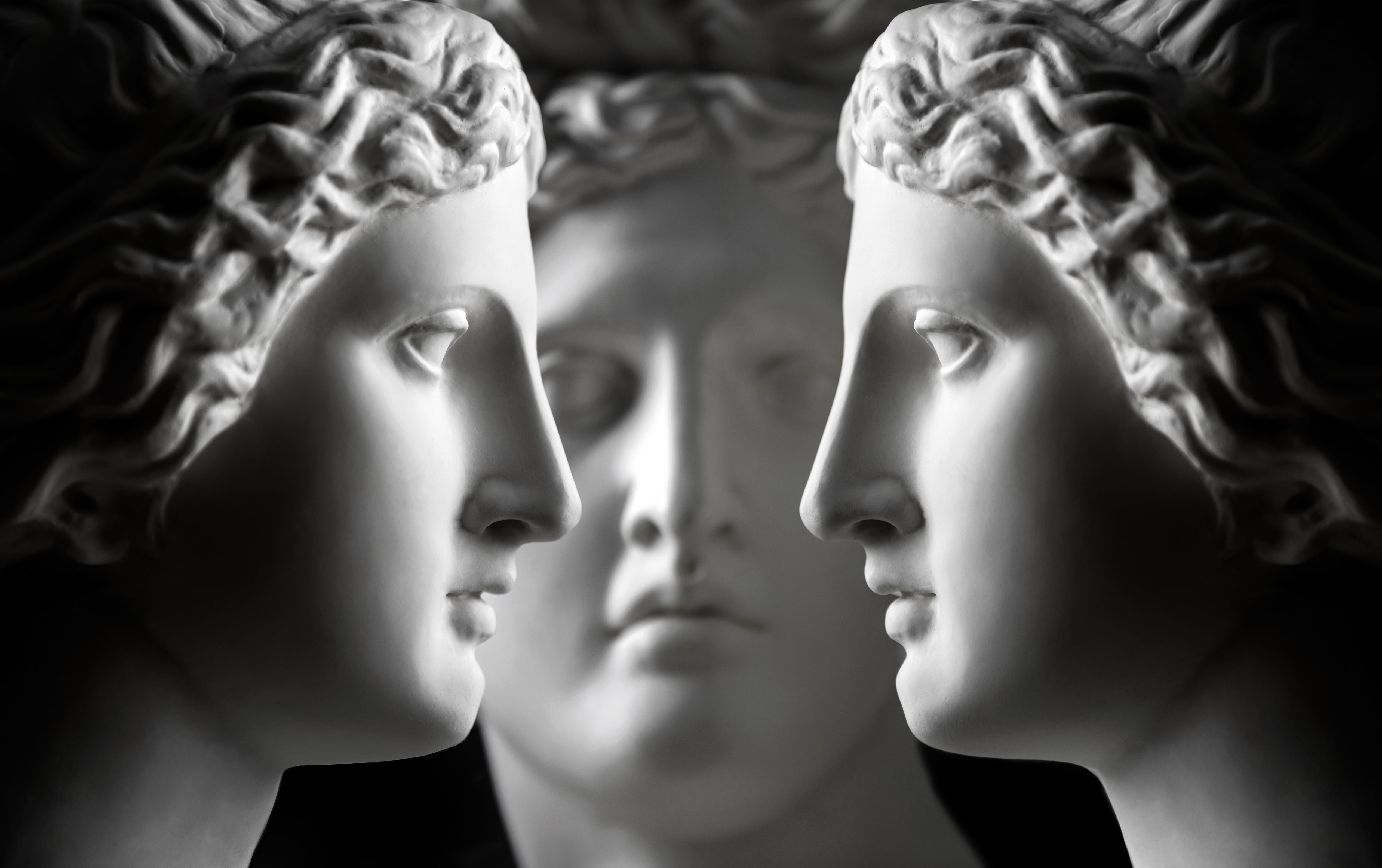 Three marble statue heads (two of Aphrodite and one of Apollo) face each other